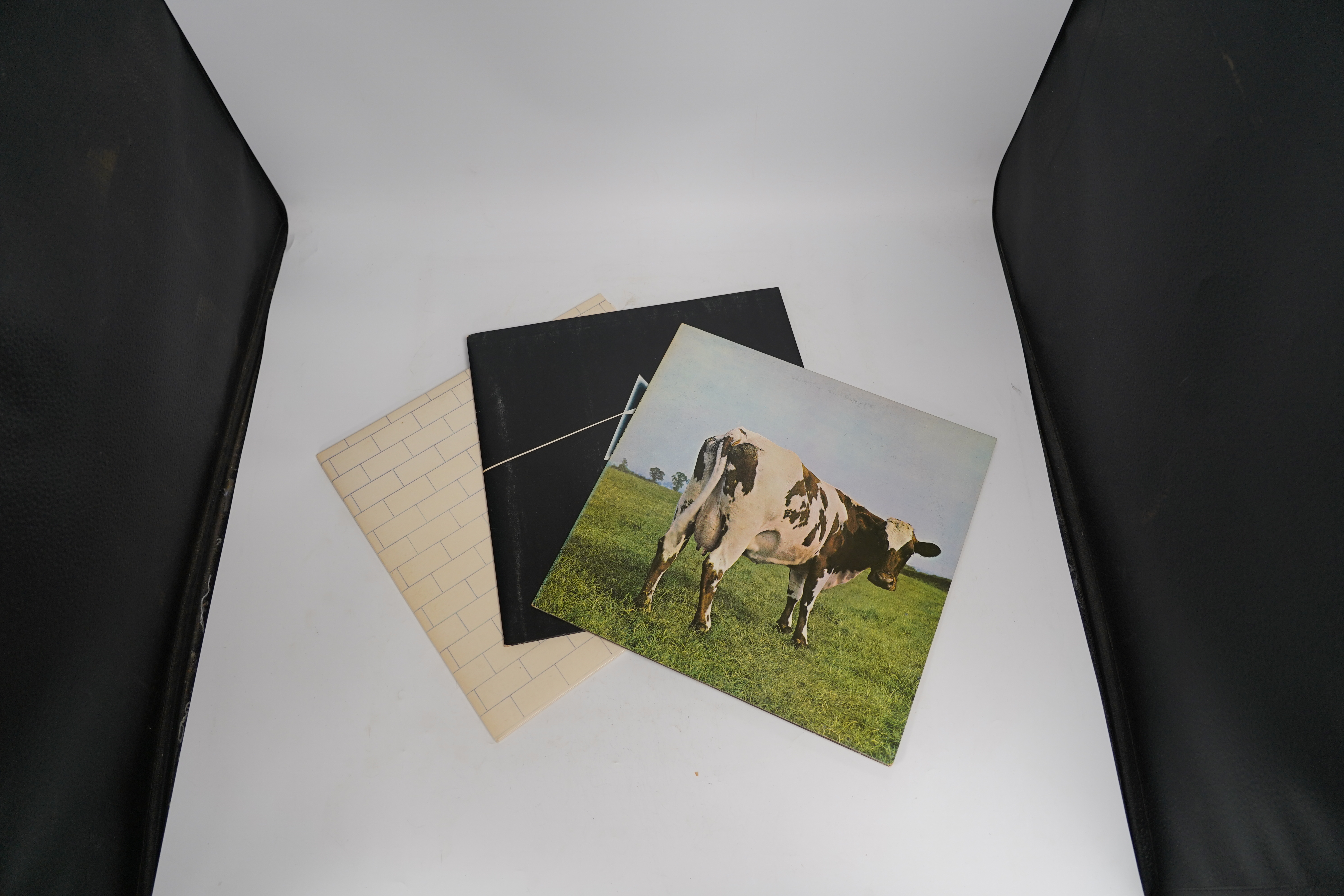 Three Pink Floyd LP record albums; The Wall, SHDW 4111, Dark Side of the Moon, SHVL804, with both posters and two postcards, Atom Heart Mother, SHVL781